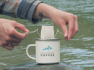 Placing pour over coffee filter over the enamel mug